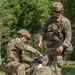 Private 1st Class Tyson Clark assesses a head injury as Master Sgt. Steven Kiser looks on