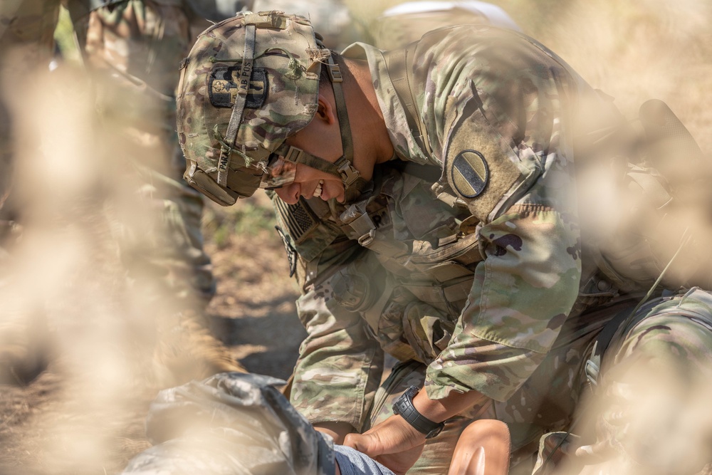 Staff Sgt. Juan Parada finishes wrapping a leg wound