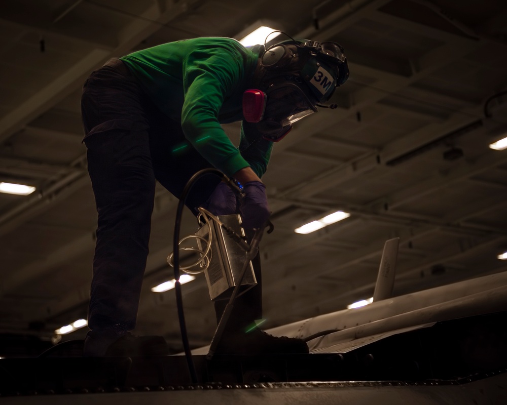 USS Carl Vinson (CVN 70) Sailor Performs Maintenance on a Jet