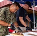 Abraham Lincoln Sailors participate in a fundraising BBQ event