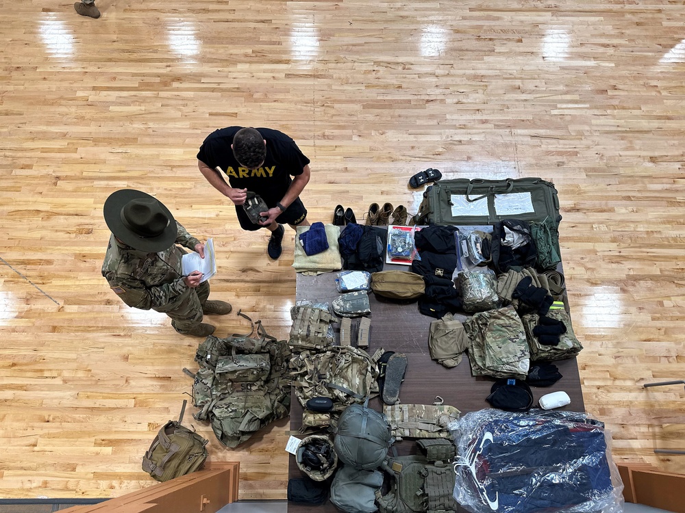 A drill sergeant speaks with a competitor during layout inprocessing