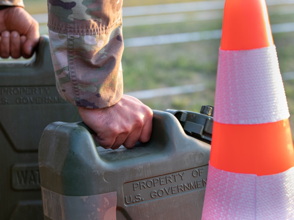 A U.S. Army Reserve soldier reaches for a water jug during an Expert Physical Fitness Assessment