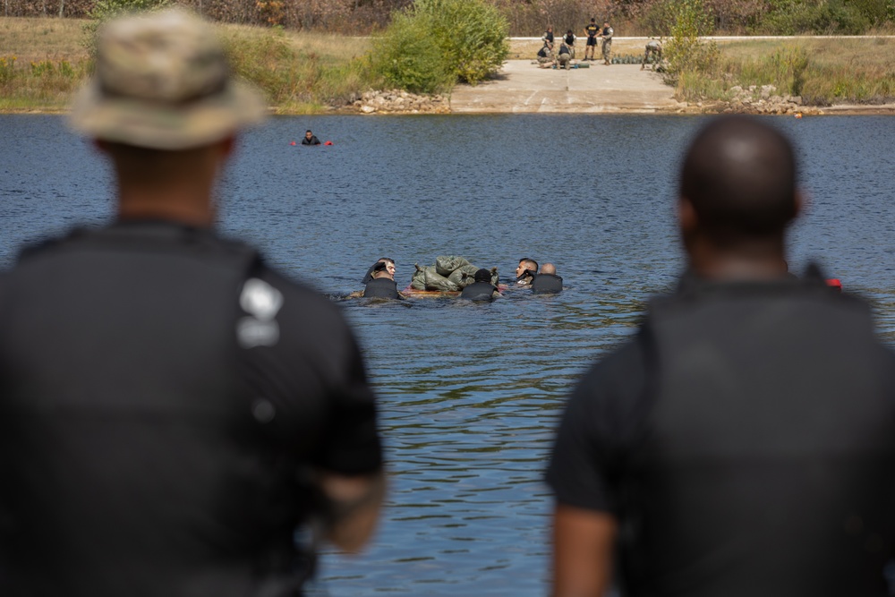 U.S. Army Best Squad Competition graders look on as a squad completes the swim event