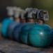 A row of M67 training grenades sit on a table