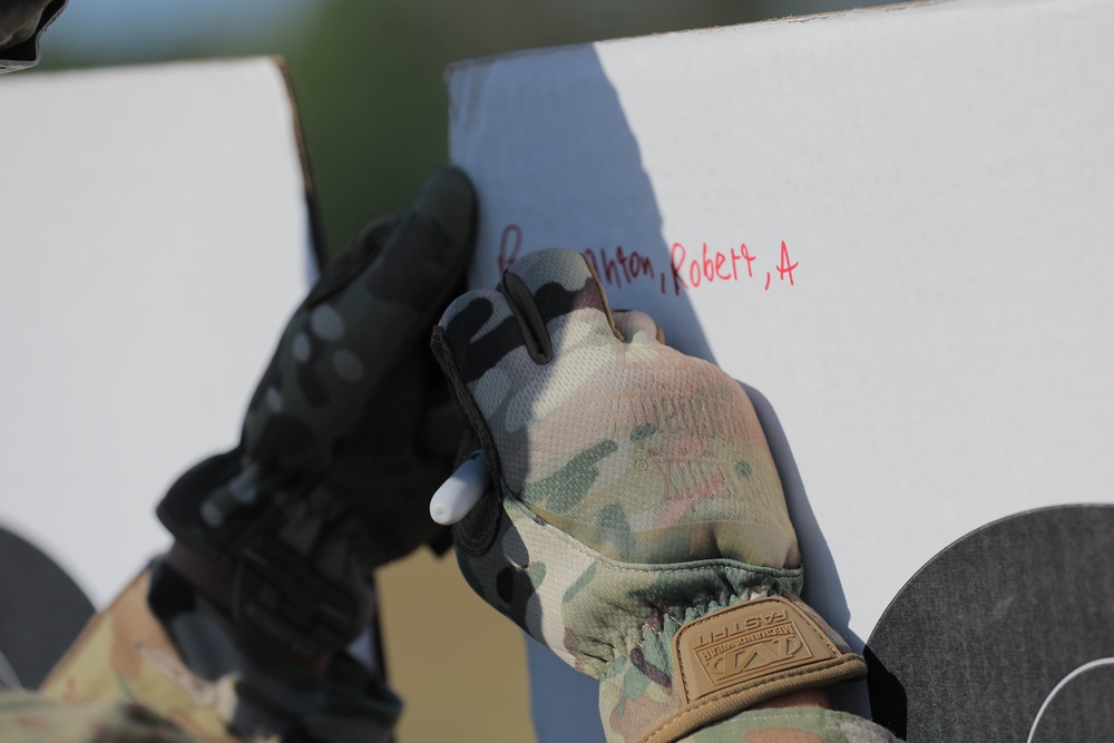 Spc. Robert Broughton writes on a target