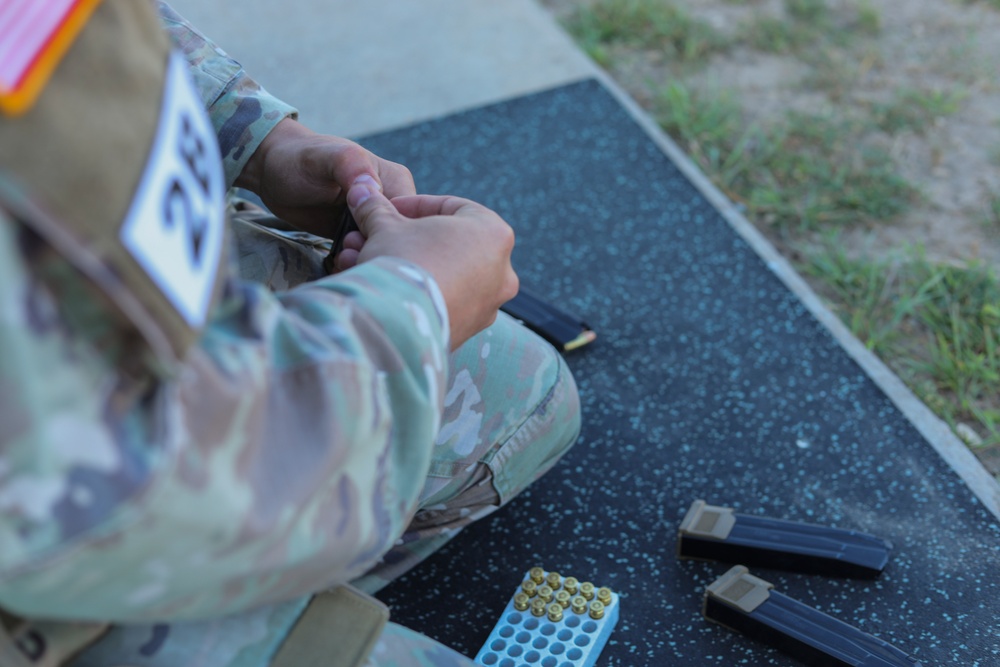 Spc. Nathaniel Wells reloads a magazine