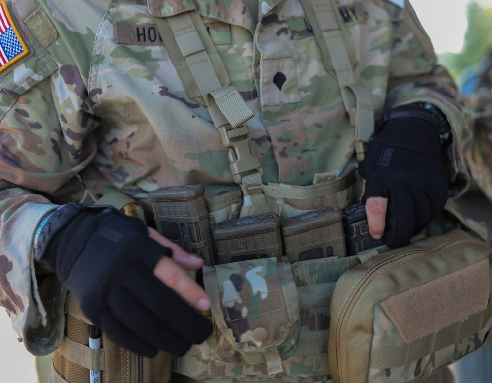 Spc. Carlin Houston fixes his M4 rifle magazines during the M17 pistol Excellence in Competition event.