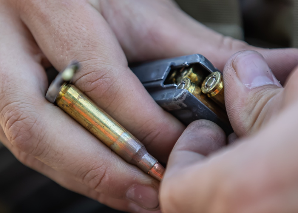 A U.S. Army Reserve Best Squad competitor loads the magazine of his M4 rifle