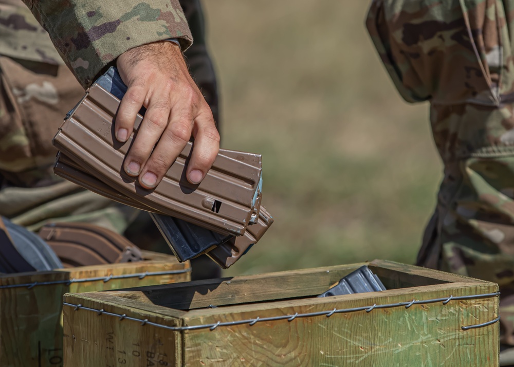 A U.S. Army Reserve Best Squad competitor drops his empty M4 rifle magazines into a collection box