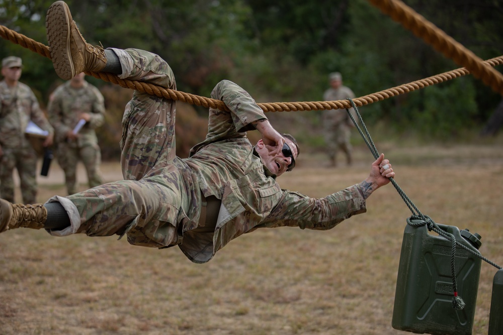 Sgt. Daniel Naes attempts to pull himself and water jugs across a rope