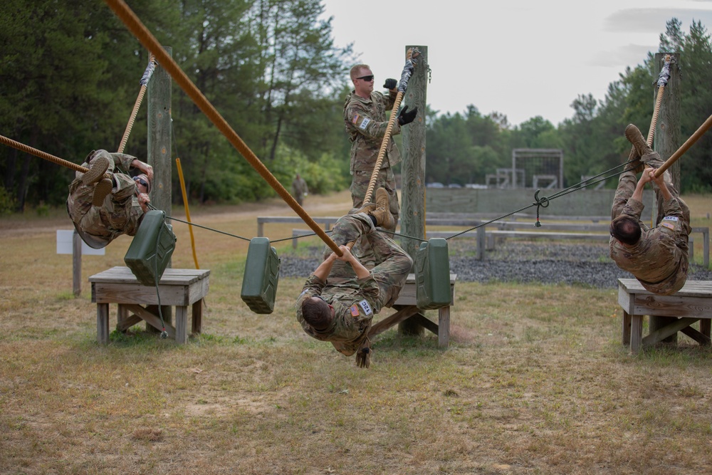 U.S. Army Reserve Best Squad competitors attempt to pull themselves and three water jugs across ropes