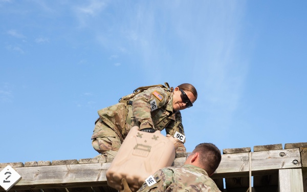 Army Reserve Best Squad competitors work together to navigate an obstacle course