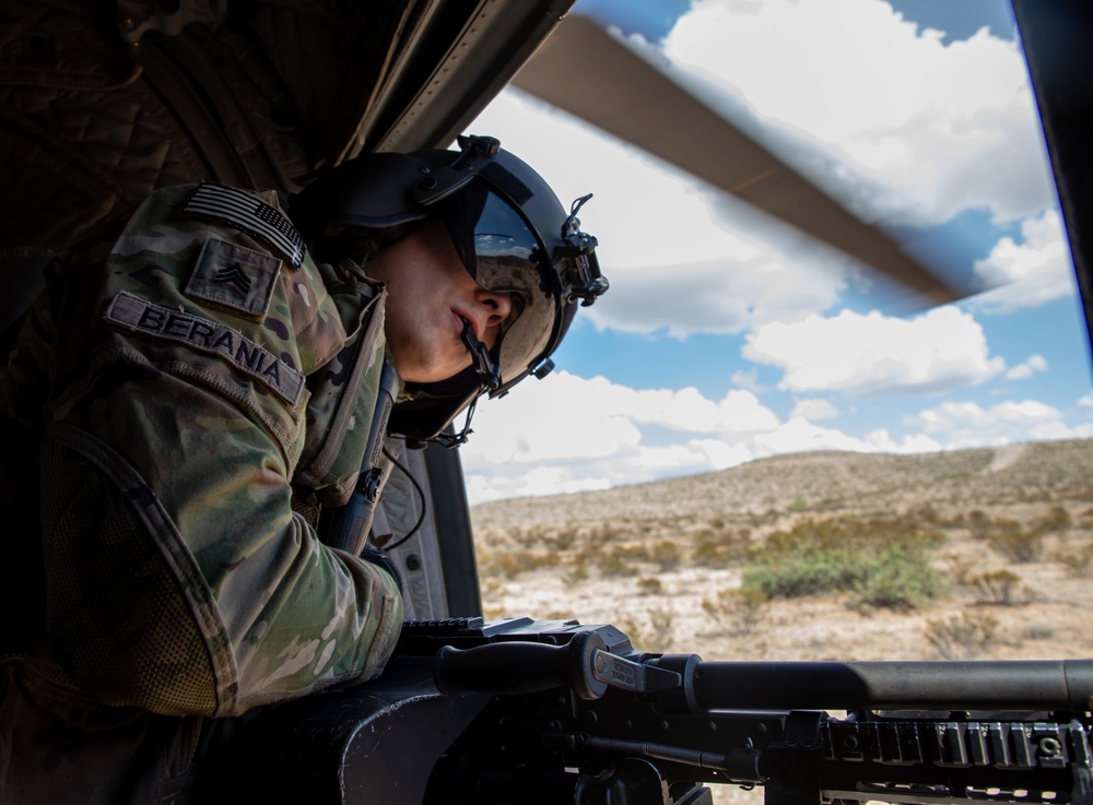 U.S. Army Door Gunner scans terrain for landing while on a CH-47F Chinook