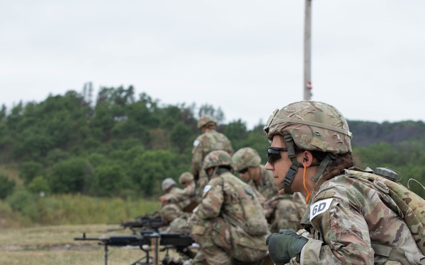 Sgt. Amanda Edgerton guides her teammate during the M249 qualification