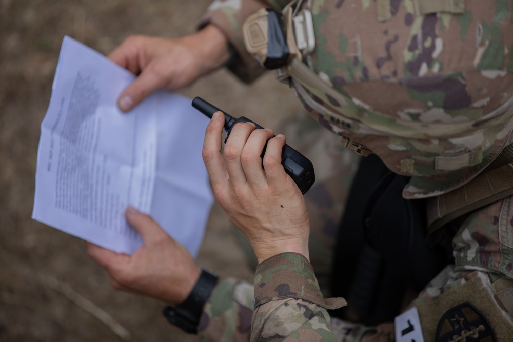 A U.S. Army Reserve Best Squad competitor speaks into a hand-held radio transmitter