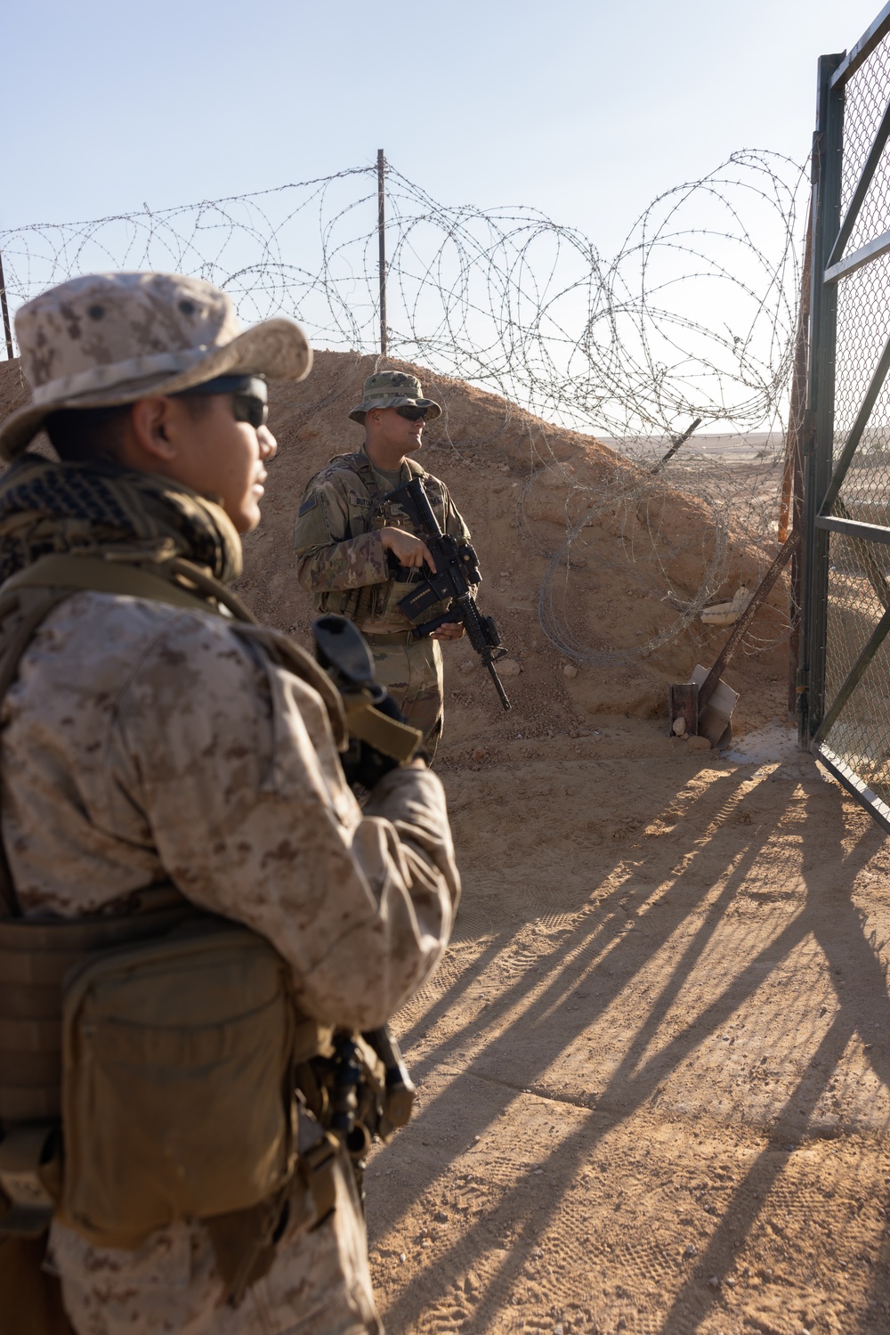 U.S. Marines, Army service members post security at an entry control point.