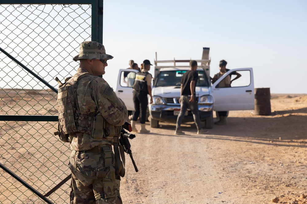 U.S. Marines, Army service members post security at an entry control point.