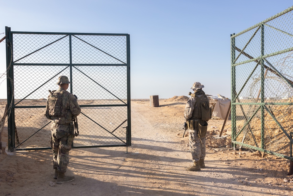 U.S. Marines, Army service members post security at an entry control point.