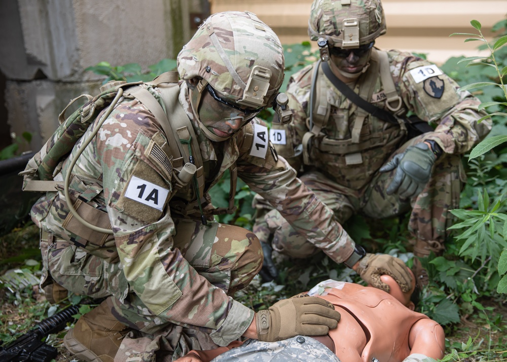 Army  Sgt. 1st Class Juan Torres applies medical assistance to a simulated casualty