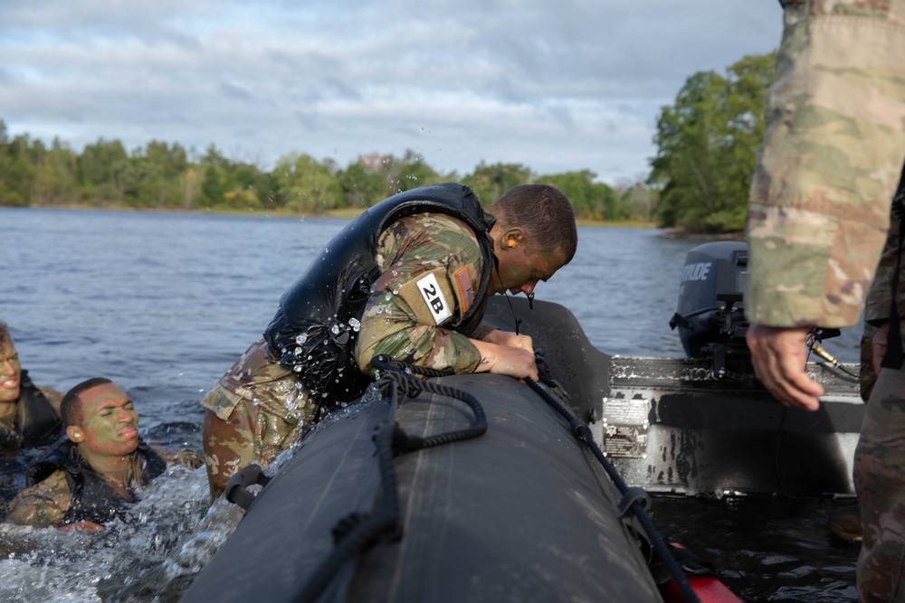 Spc. Nathaniel Wells pulls himself into a zodiac boat