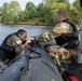 Spc. Nathaniel Wells helps teammate Spc. Maynard Delphin into a zodiac boat