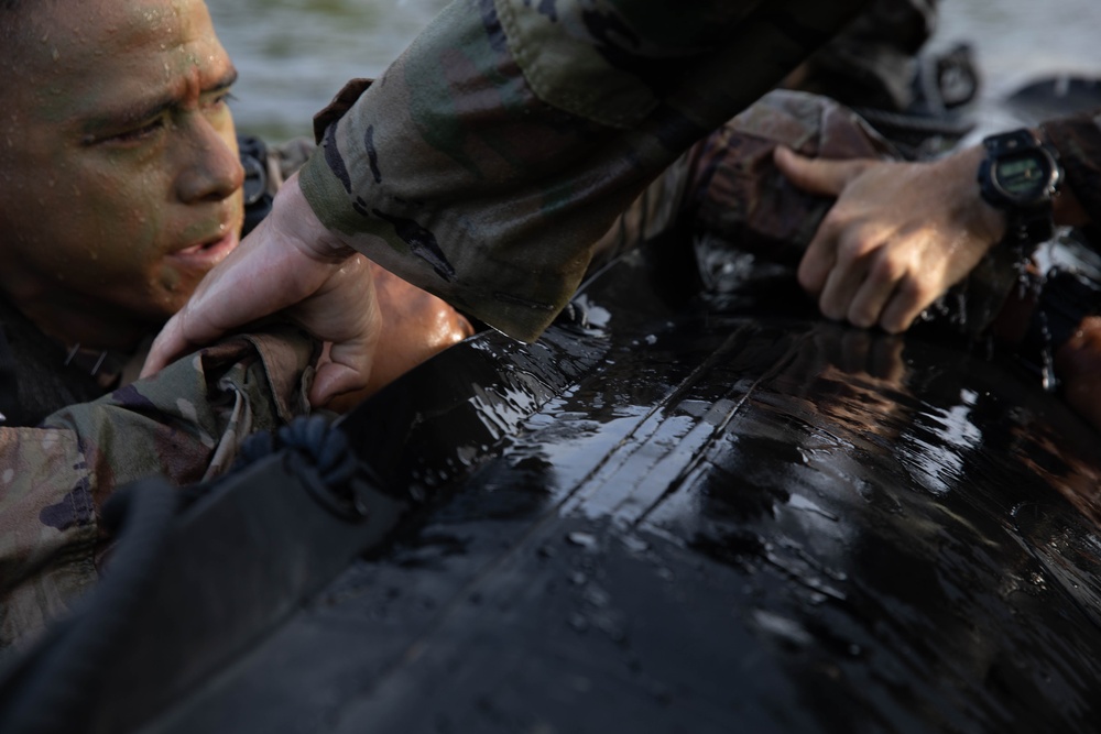 Army Reserve Best Squad competitors help their teammates into the zodiac boat