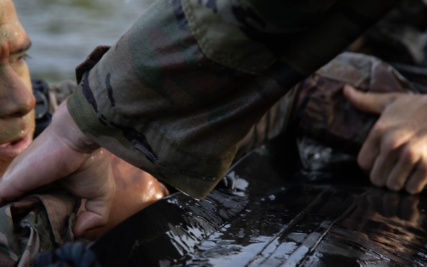 Army Reserve Best Squad competitors help their teammates into the zodiac boat