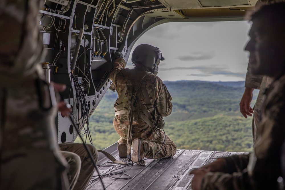 A U.S. Army reserve soldier kneels on the loading ramp of a CH-47 Chinook