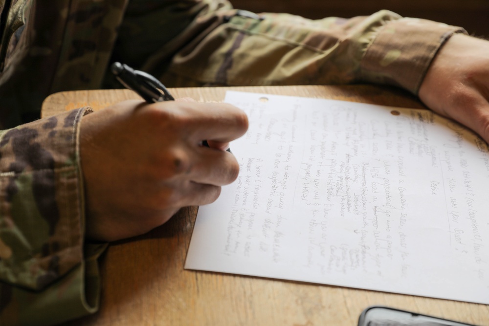 A U.S. Army Best Squad Competitor writes during the essay preparation event