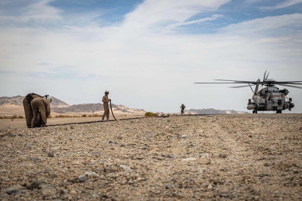 U.S. Navy MQ-8C Fire Scout first time ground refueling by U.S. Marine Corps CH-53E Super Stallion