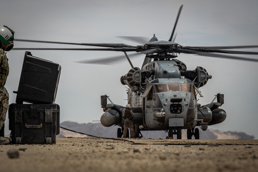 U.S. Navy MQ-8C Fire Scout first time ground refueling by U.S. Marine Corps CH-53E Super Stallion