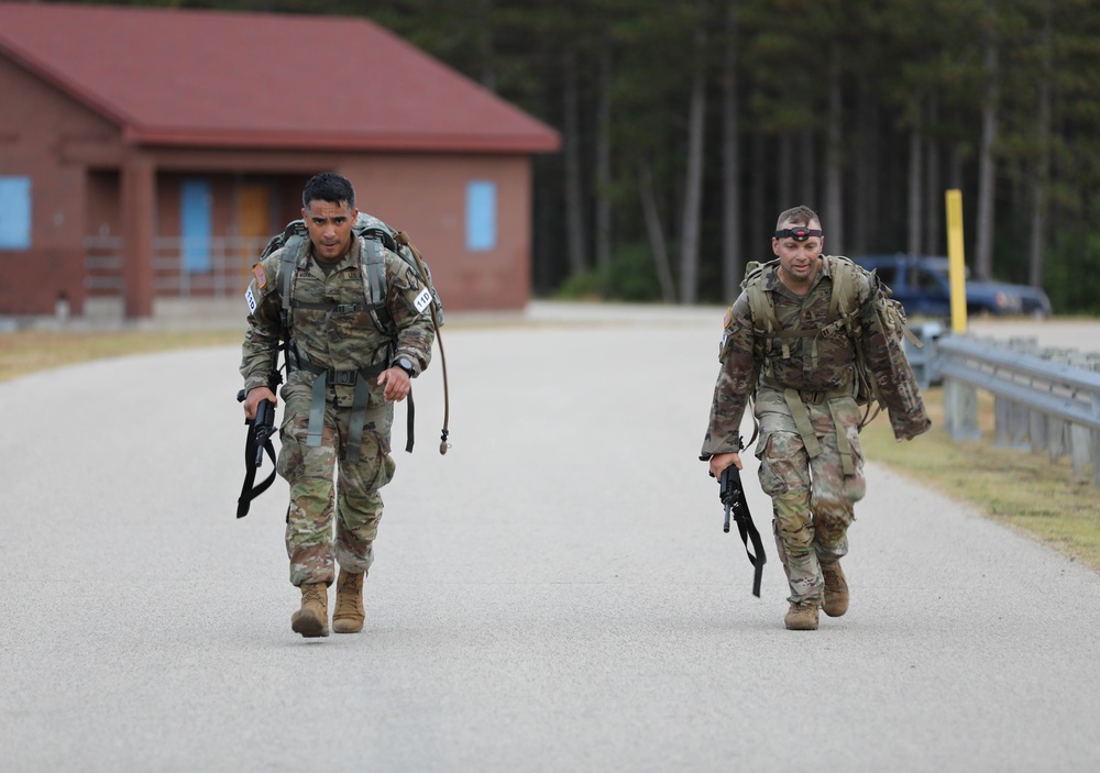 Spc. Christian Jaen-Morales (left) and Sgt. 1st Class Christopher McBride (right) head toward the finish of a 12 mile ruck march