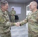 Commander presents coins to outgoing troops