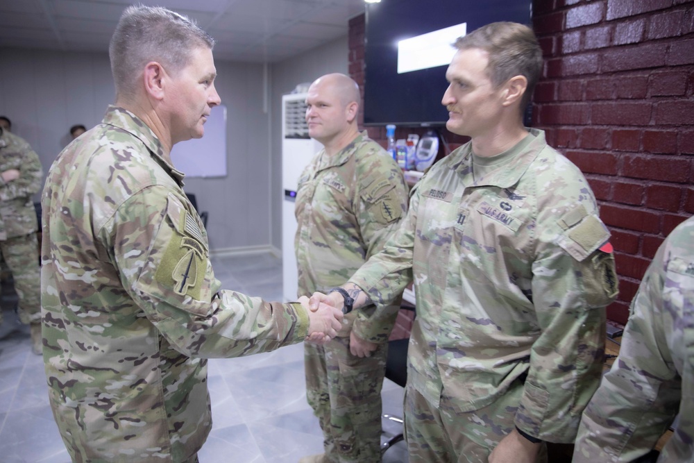 Commander presents coins to outgoing troops