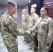 Commander presents coins to outgoing troops