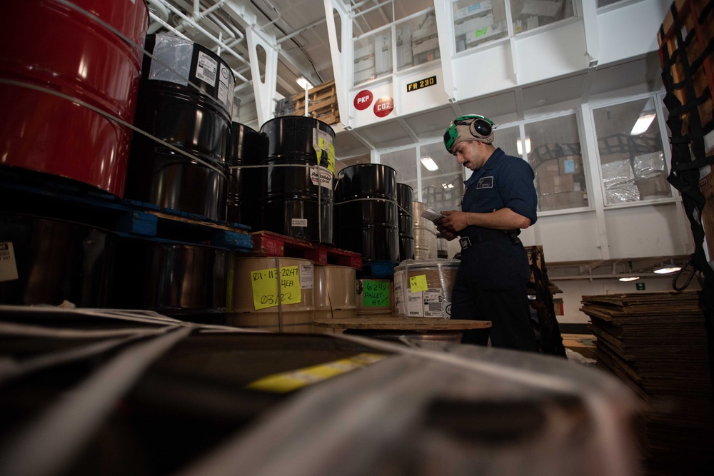 Sailor Accounts for Inventory in the Hangar Bay of USS Carl Vinson (CVN 70)