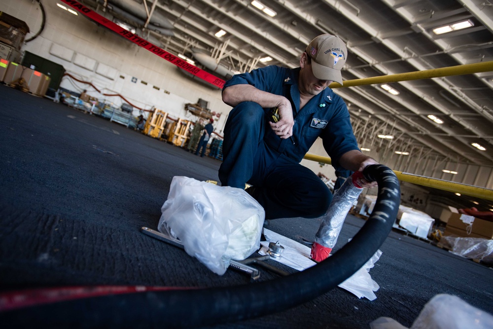 Sailor Monitors Lube Transfer in the Hangar Bay of USS Carl Vinson (CVN 70)