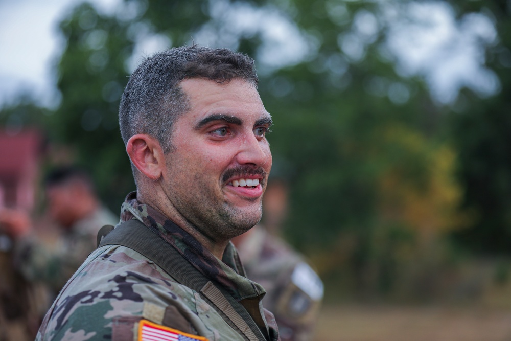 Spc. Anthony Caldarella celebrates finishing the 12 mile ruck march