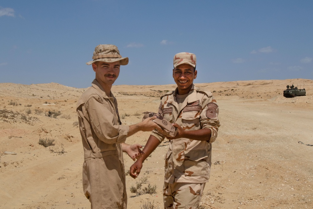 U.S. Marine shares a meal ready to eat with an Egyptian soldier before the start of a dry fire rehearsal in support of exercise Bright Star 2023