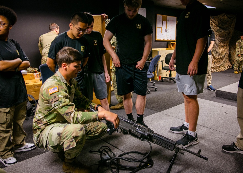 Future Soldiers observe as a Soldier teaches them how to properly handle a weapon