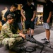 Future Soldiers observe as a Soldier teaches them how to properly handle a weapon
