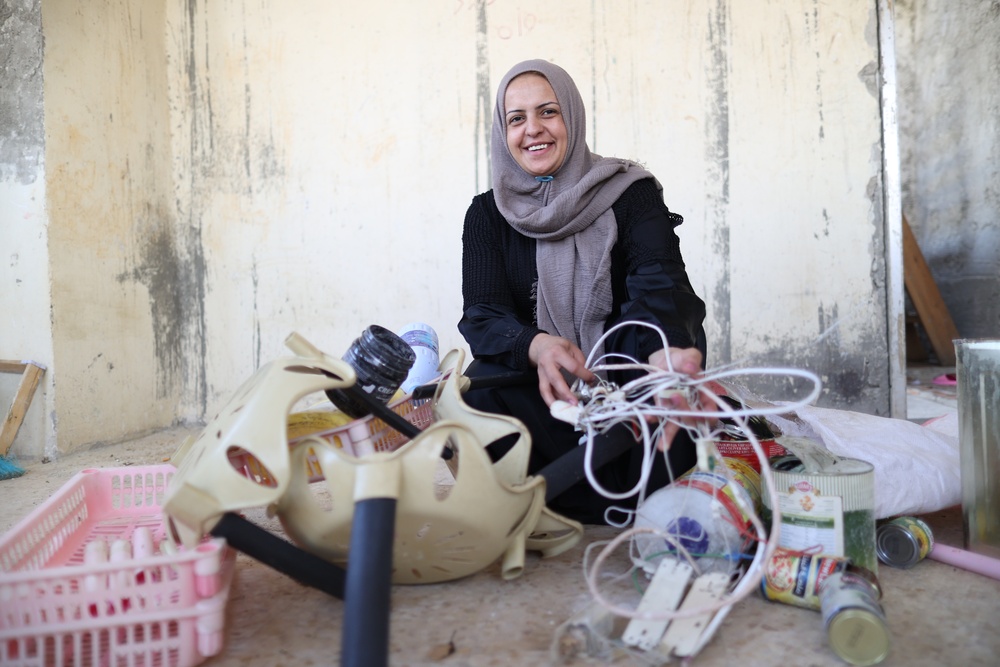 Waste picker Maha Dakkak sorts plastic and metal scrap in her home’s storage room.