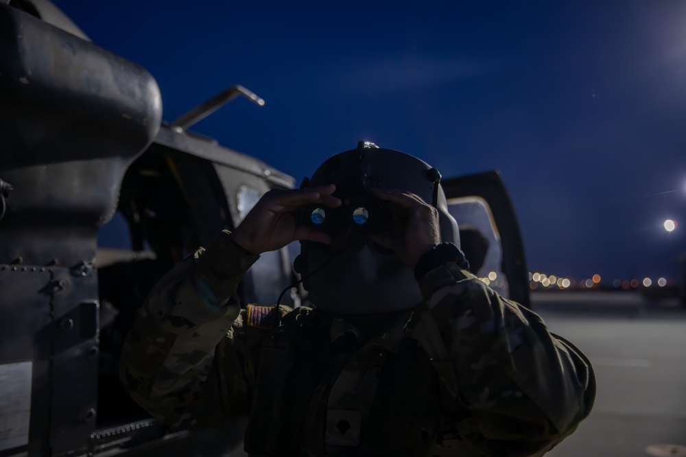 U.S. Army Door Gunner checks his night vision goggles