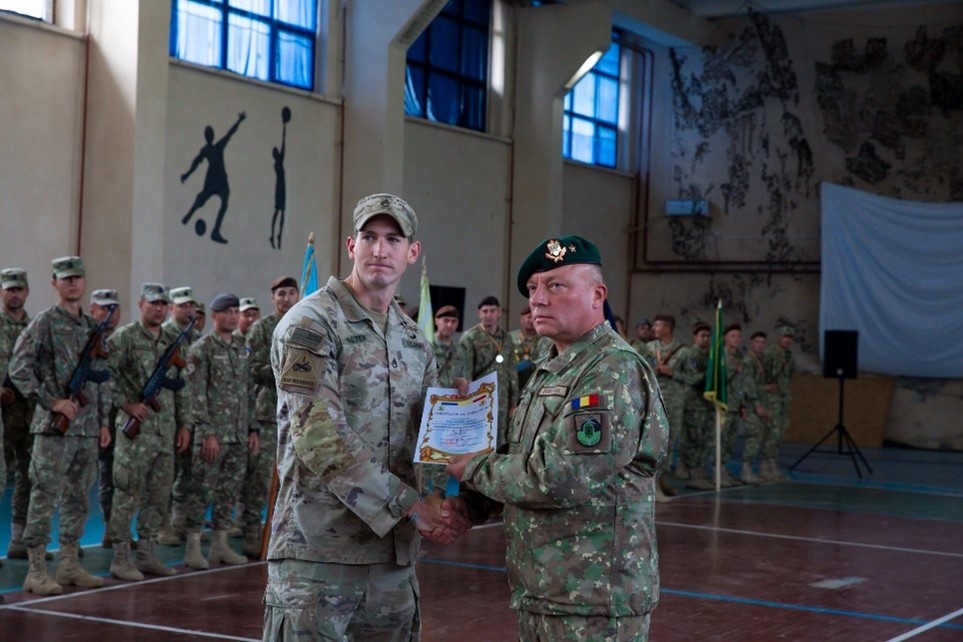 Romanian Brig. Gen. Ilie-Marian Dragomir recognizes U.S. Army Staff Sgt. Joseph Halter for winning first place in the hand grenade employment lane