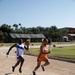 Military personnel from multiple countries run in an organized track meet