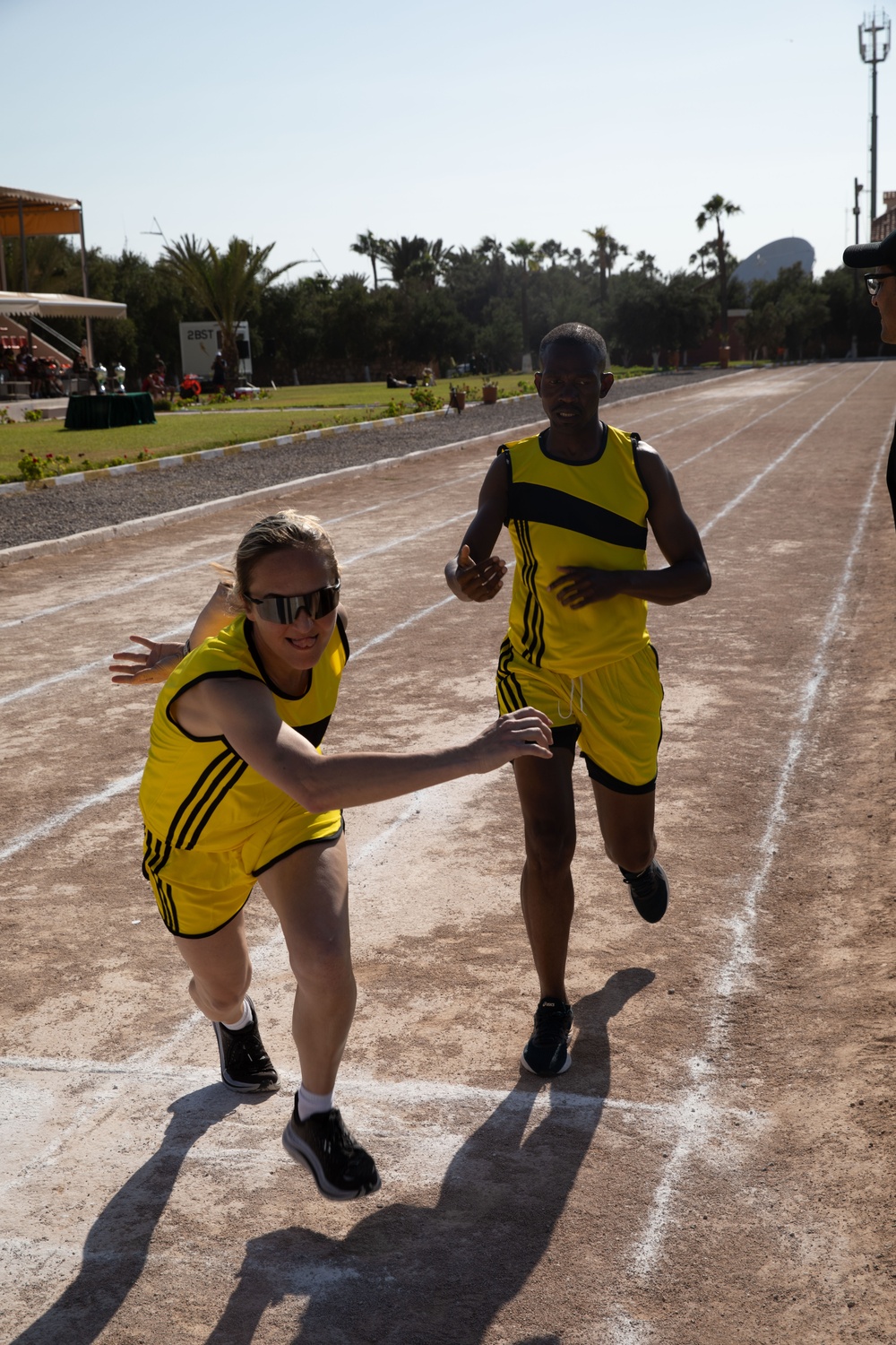 Military personnel from multiple countries run in an organized track meet