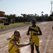 Military personnel from multiple countries run in an organized track meet