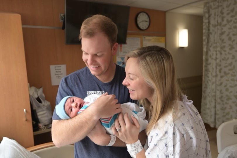 Lt. Nathan Henderson (left) with wife Claire and newborn baby Everett