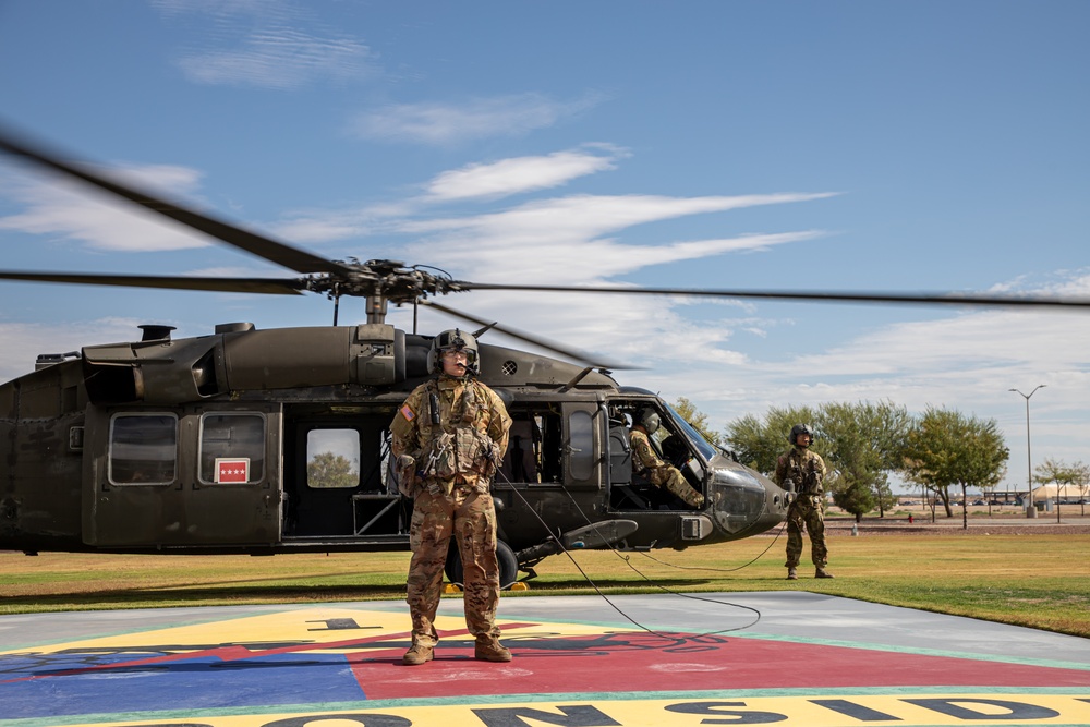 U.S. Army Door Gunner stands by with UH-60M Black Hawk