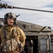 U.S. Army Door Gunner stands by with UH-60M Black Hawk